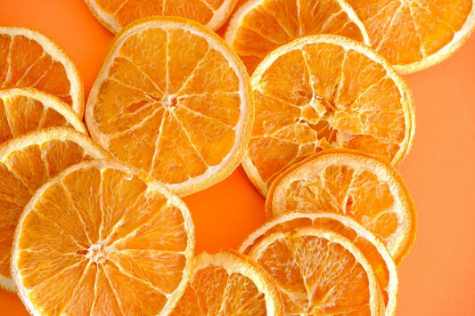 Plusieurs tranches d'orange répartie sur un fond orange - MynutriformOrange Vitamine C